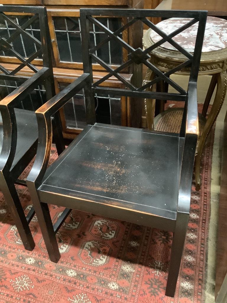 A pair of George III style ebonised elbow chairs